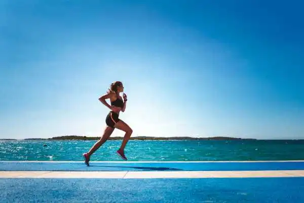 Woman running showing strong leg muscle Byfleet